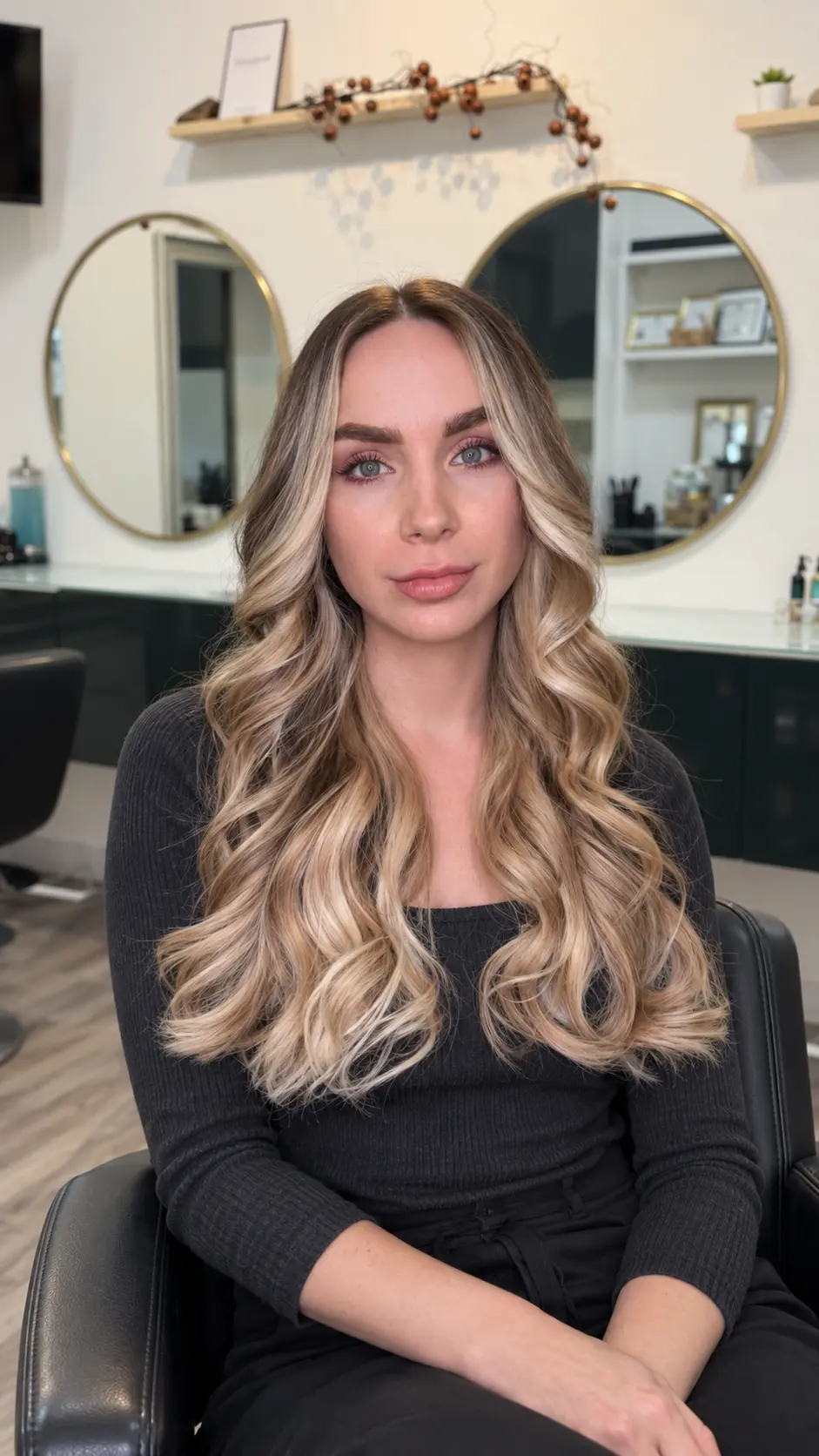 Client with long dimensional blonde extensions seated in Nasrin Salon