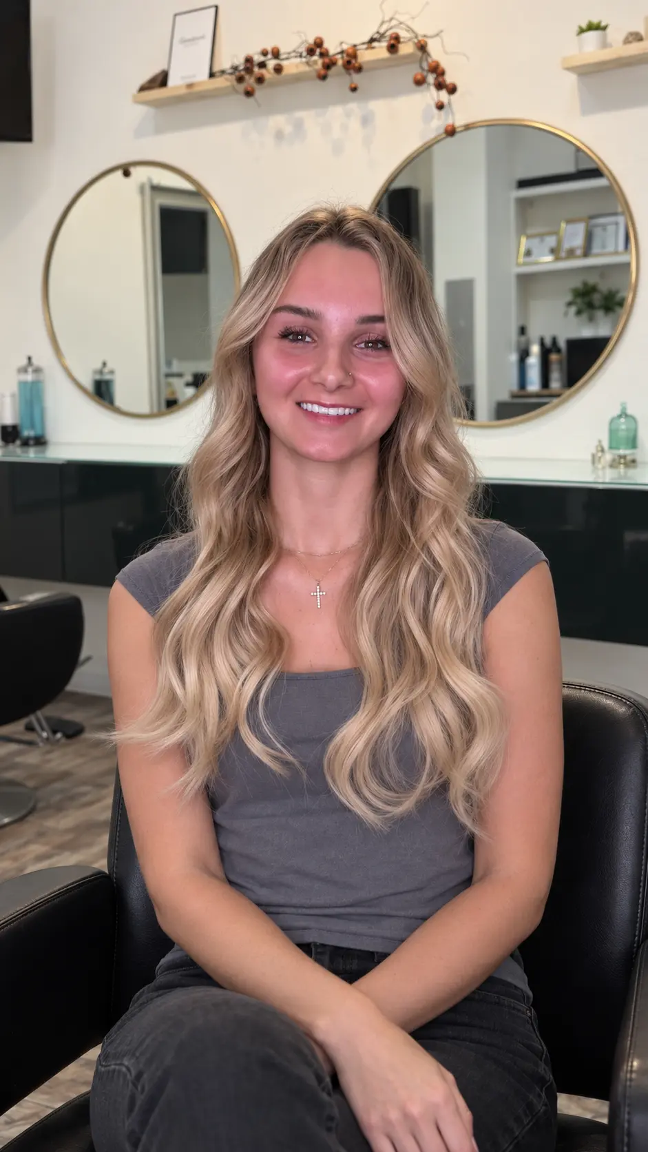 Client with long soft blonde waves seated in Nasrin Salon